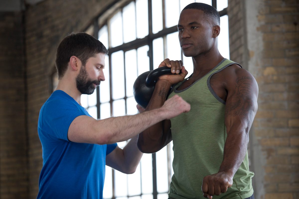 Matt Semrick coaching a client on kettlebell press form